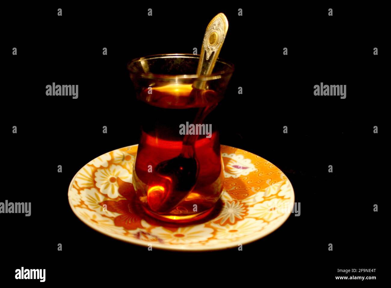 Einfache türkische Tasse Tee mit Löffel isoliert auf schwarz Stockfoto