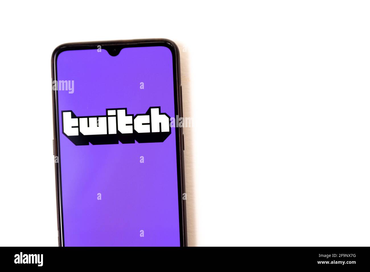 Barcelona, Spanien - 20. april 2021: Ein Mobiltelefon auf weißem Hintergrund mit Twitch-Live-Streaming-App und Kopfhörer, die für Live-Feeds bereit sind. Twitch ist Stockfoto