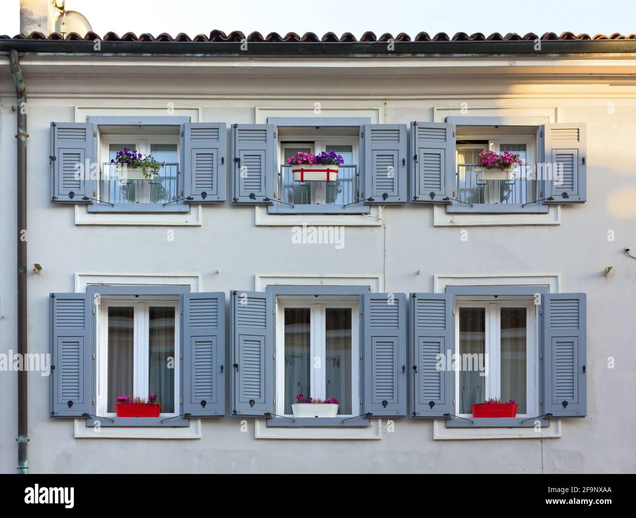 GRADISCA D'ISONZO, Italien - 20. April 2018: Detail der eleganten Fassade eines Hauses mit schönen Blumen auf den Fensterbänken Stockfoto
