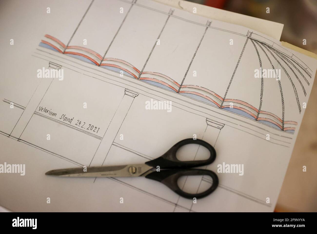 20. April 2021, Sachsen-Anhalt, Bad Lauchstädt: Eine Schere liegt auf einer Zeichnung der historischen Festzelt-Decke des Goethe-Theaters. Die Restaurierung nach dem Original aus dem Jahr 1802 ist nach fünf Monaten abgeschlossen. Das Theater wurde 1802 unter der Leitung von Johann Wolfgang von Goethe (1749-1832) erbaut. Heute ist es das einzige original erhaltene Theatergebäude aus Goethes Zeit. Die gesamte Renovierung des Innenraums wird voraussichtlich bis Juli abgeschlossen sein. Insgesamt sollen 2.6 Millionen Euro in das Gebäude investiert werden. Foto: Jan Woitas/dpa-Zentralbild/dpa Stockfoto