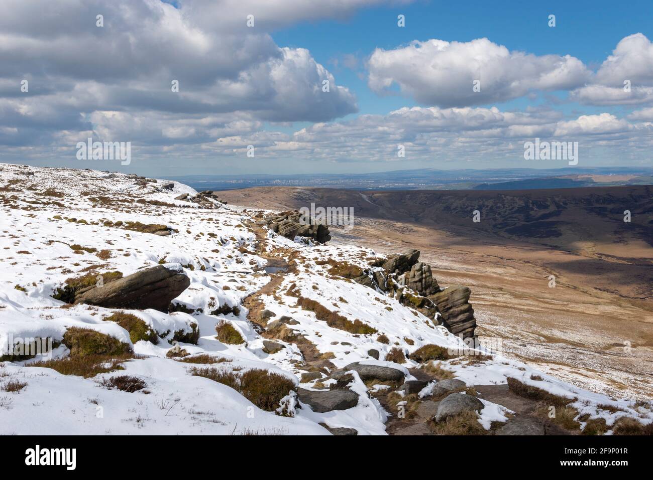 Pfad entlang des nördlichen Randes von Kinder Scout mit Blick auf die Pennine Moors mit ungewöhnlicher Mischung aus Schnee und April-Sonnenschein. Stockfoto