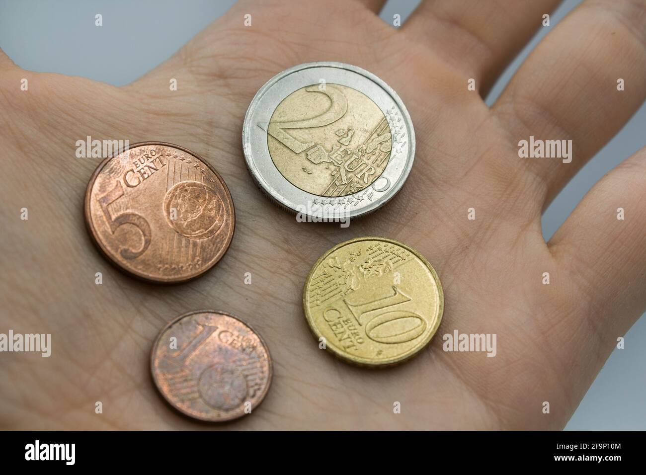 Euro-Münzen zur Hand, Konzept der Finanzkrise, Inflation und Rezessionsproblem. Stockfoto