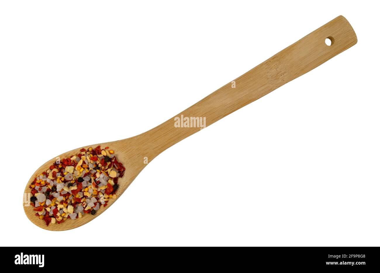 Holzlöffel gefüllt mit Knoblauch und Chili Gewürz isoliert auf einem weißen Hintergrund. Stockfoto