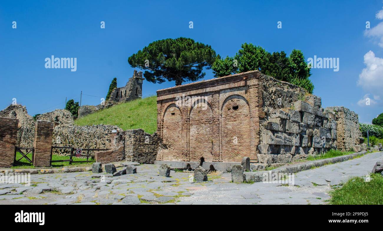 Die Menschen schlendern durch einen der wenigen gepflegten Gärten im Inneren des pompeji-Ruinenkomplexes in der Nähe des italienischen neapel. Stockfoto