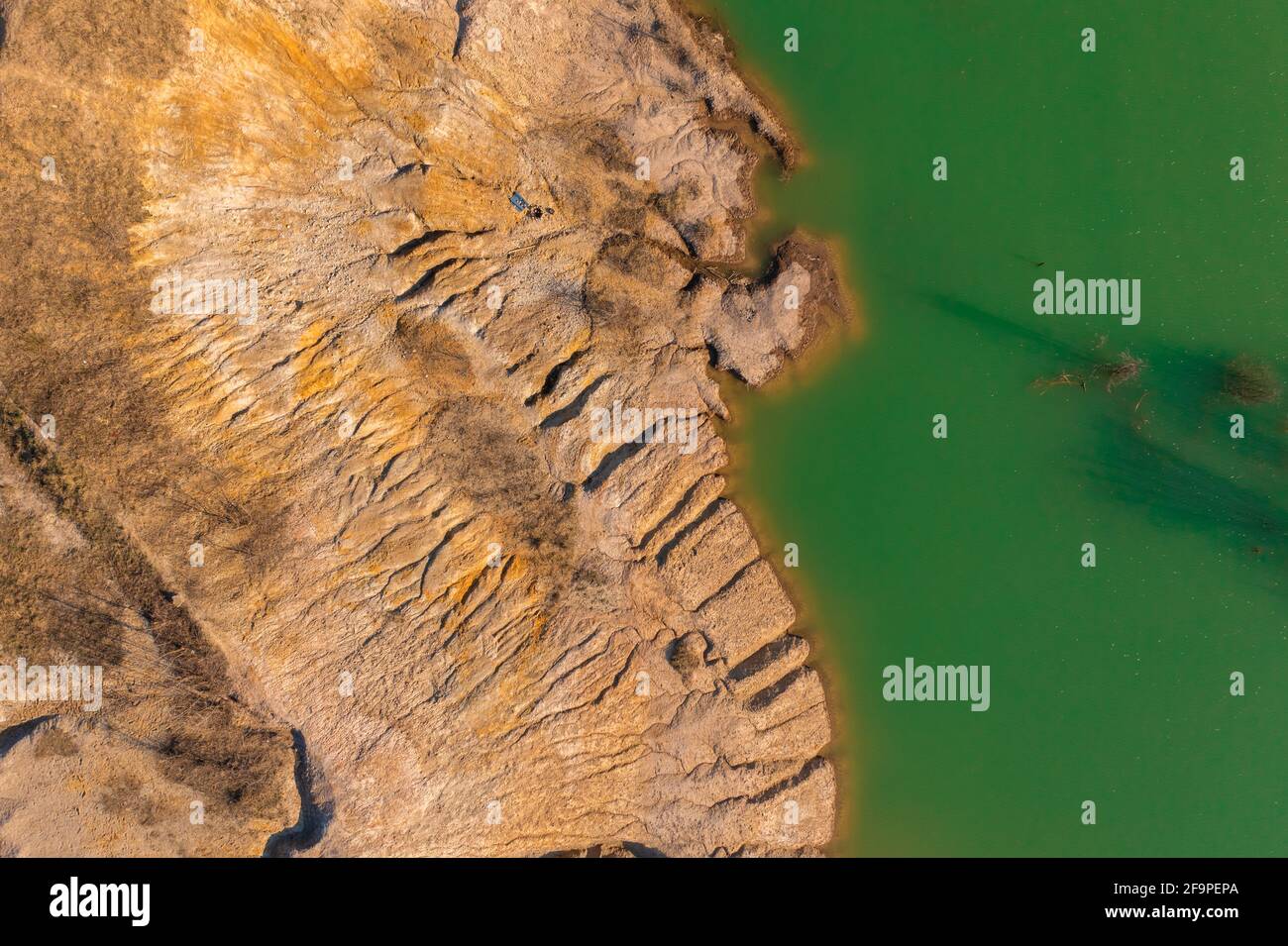 Solymár, Ungarn - Luftbild über felsige Küste mit grün gefärbtem Wasser. Stockfoto