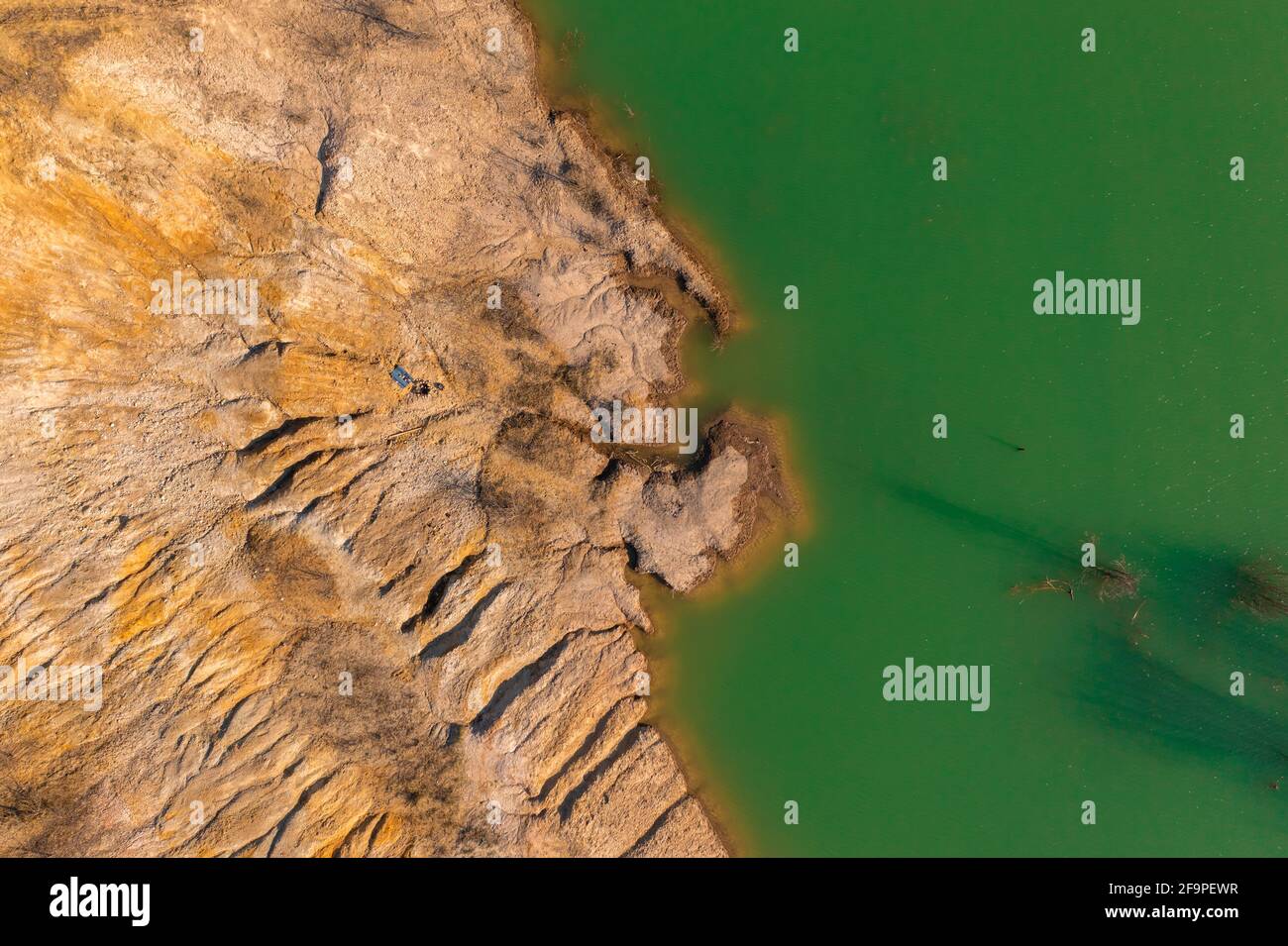 Solymár, Ungarn - Luftbild über felsige Küste mit grün gefärbtem Wasser. Stockfoto