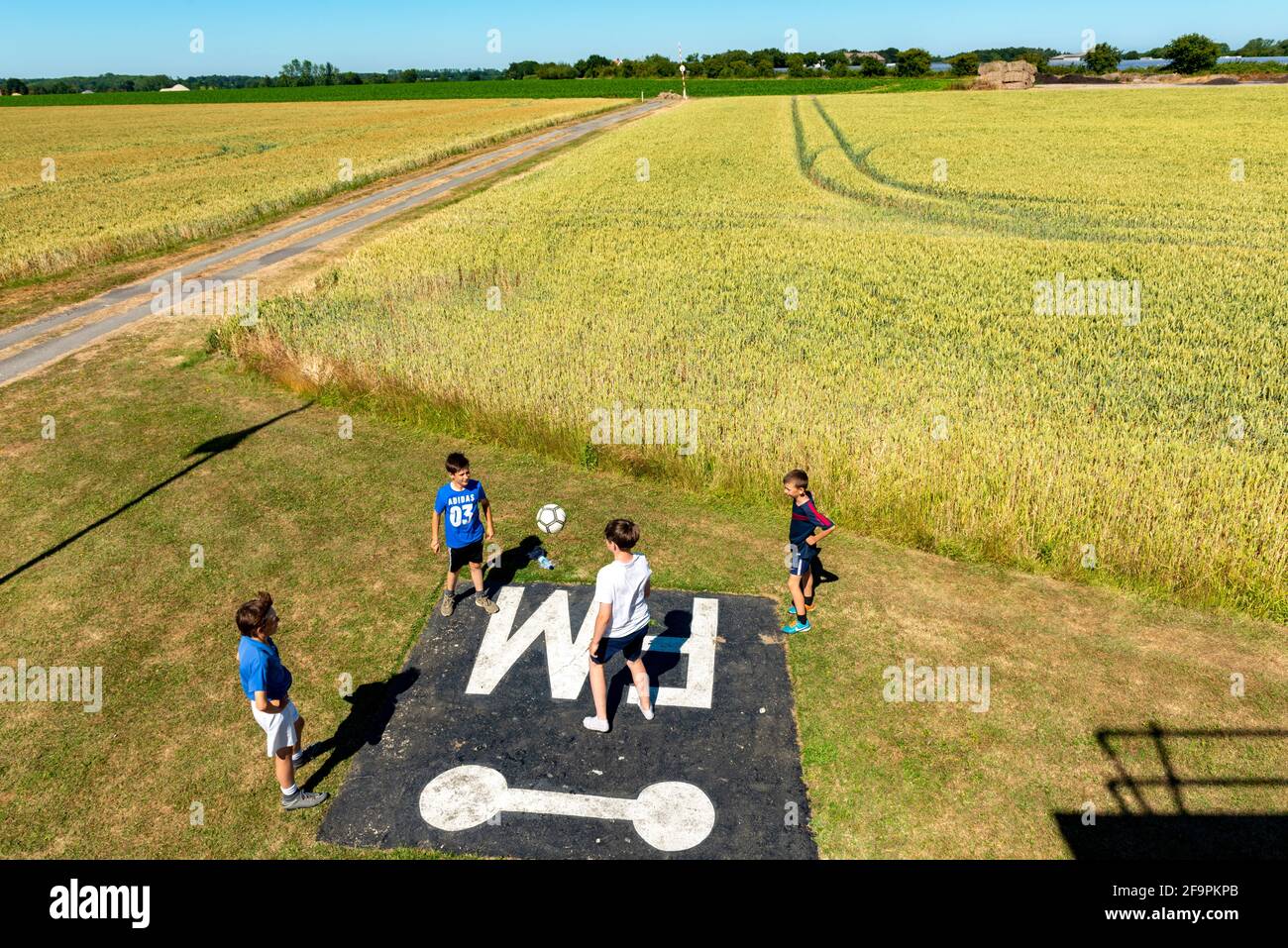 Boys spielend Fußball, Parham Airfield Suffolk UK Stockfoto