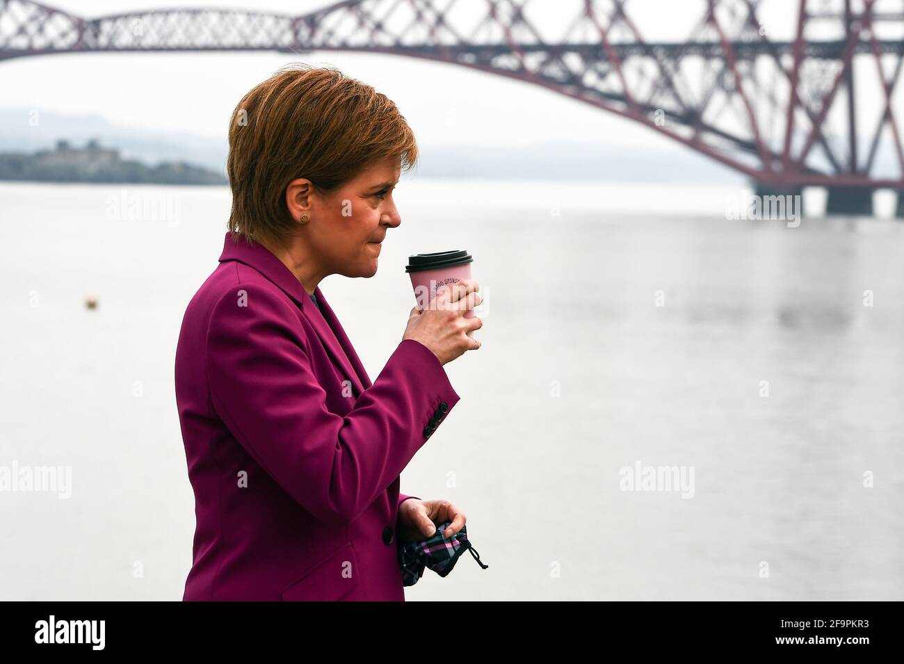 Schottlands erste Ministerin Nicola Sturgeon, Vorsitzende der Scottish National Party (SNP), neben dem Firth of Forth und der Forth Bridge, während sie in South Queensferry für die schottischen Parlamentswahlen kämpft. Bilddatum: Dienstag, 20. April 2021. Stockfoto