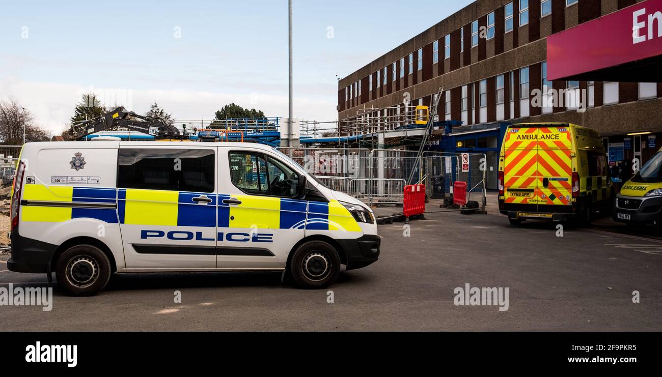 Ein Polizeiwagen parkte zwischen den Krankenwagen im Diana Princess of Wales Hospital, Grimsby, und zeigte unsere gestreckten Frontservices in der Pandemie Stockfoto