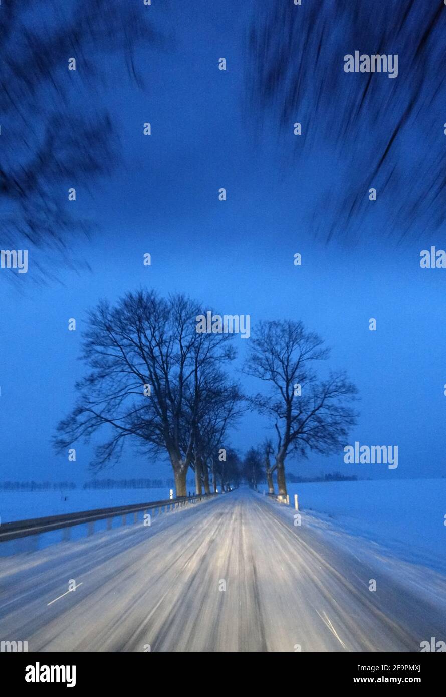 30.01.2021, Jueterbog, Brandenburg, Deutschland - Schneebedeckte Landstraße im Morgengrauen. 00S210130D371CAROEX.JPG [MODEL RELEASE: NO, PROPERTY RELEASE: NO (C) Stockfoto