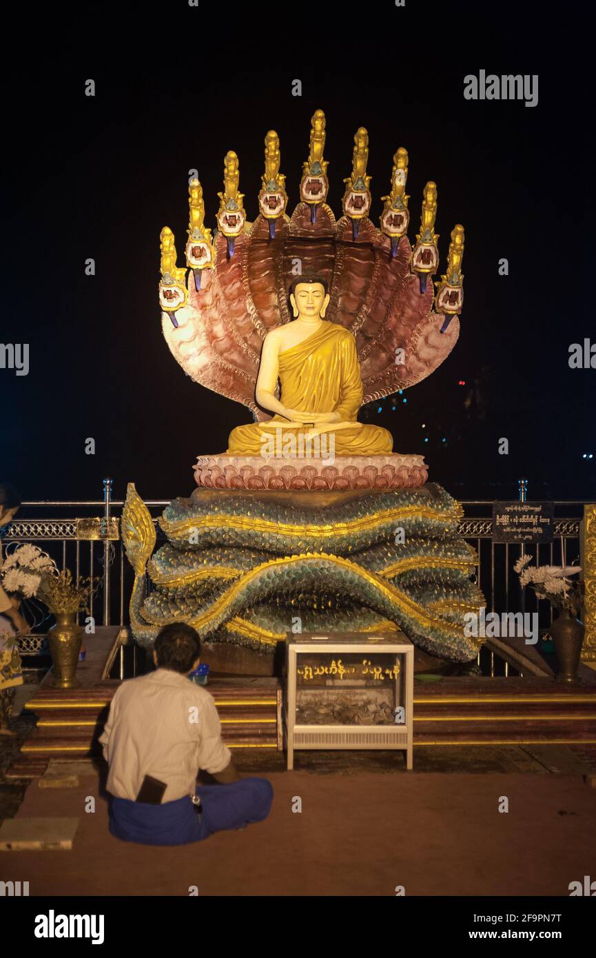 30.01.2017, Mawlamyine, Mon State, Myanmar - Gläubige vor einer beleuchteten Buddha-Gestalt in der Kyaikthanlan-Pagode, dem höchsten buddhistischen pa der Stadt Stockfoto