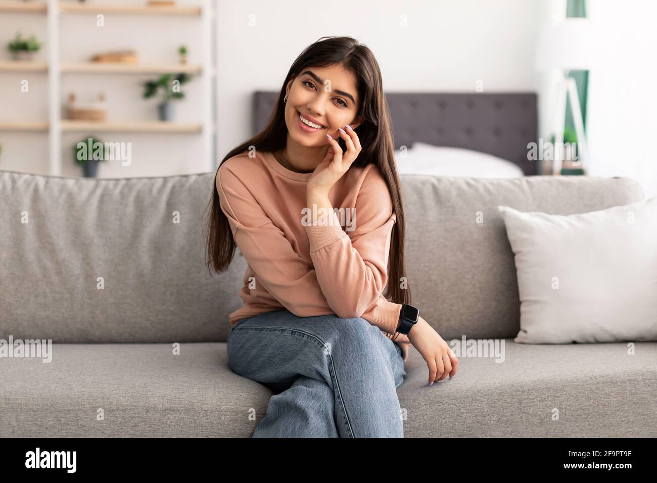 Porträt einer jungen Frau, die lächelt und vor der Kamera posiert Stockfoto