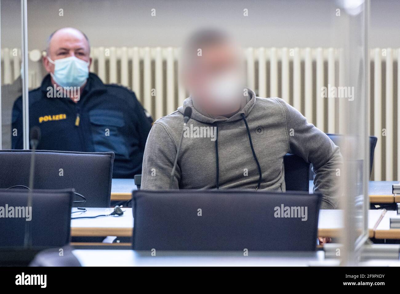 Regensburg, Deutschland. April 2021. Der Angeklagte (r) sitzt im Gerichtssaal des Landgerichts. Wegen eines Brandanschlags auf einen SEK-Offizier wurde der 42-Jährige wegen versuchten Mordes zu sieben Jahren Gefängnis verurteilt. Quelle: Armin Weigel/dpa - ACHTUNG: Person wurde aus rechtlichen Gründen pixeliert/dpa/Alamy Live News Stockfoto