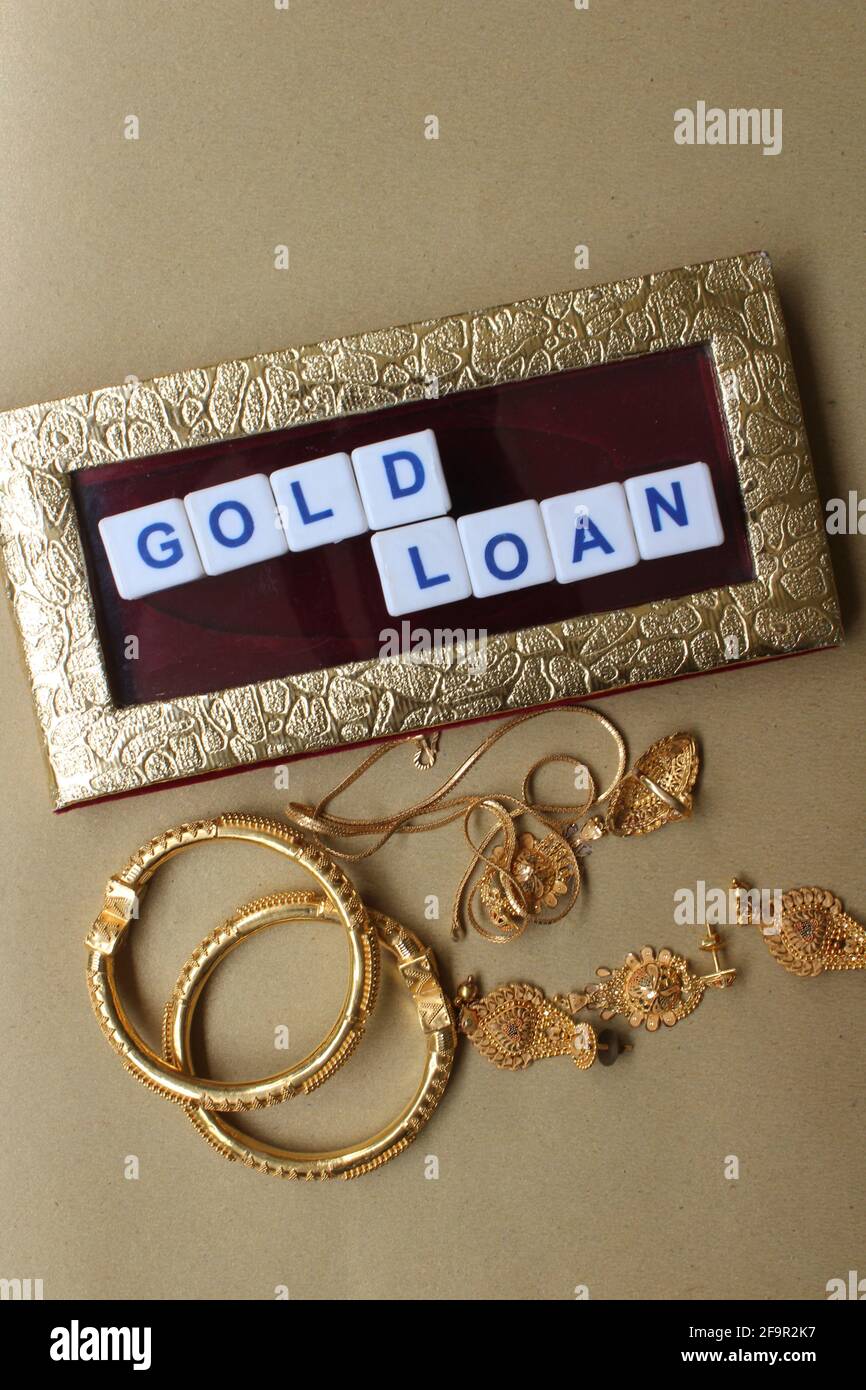 Darstellung des Goldkreditkonzepts durch Plastikblöcke, Wörter und Schmuck Stockfoto