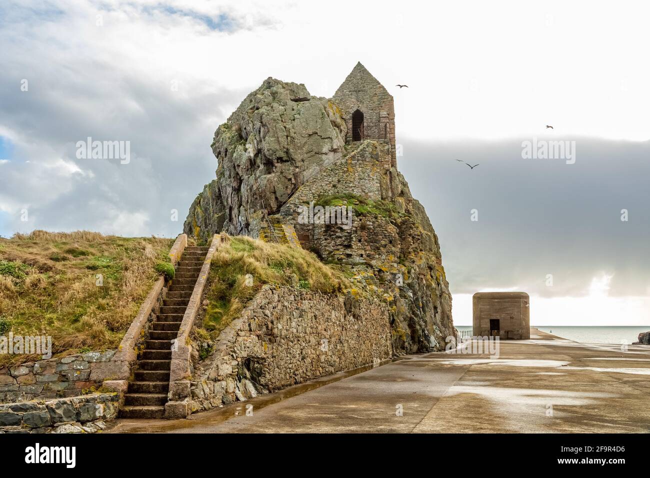 St. Helier Einsiedelei mit mittelalterlicher Kapelle auf der Oberseite mit deutschen bunker im Hintergrund, Vogtei von Jersey, Kanalinseln Stockfoto