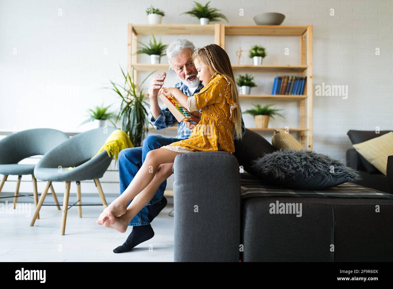 Großeltern genießen die Zeit lachen mit kleinen Mädchen Enkelkind zu Hause Stockfoto