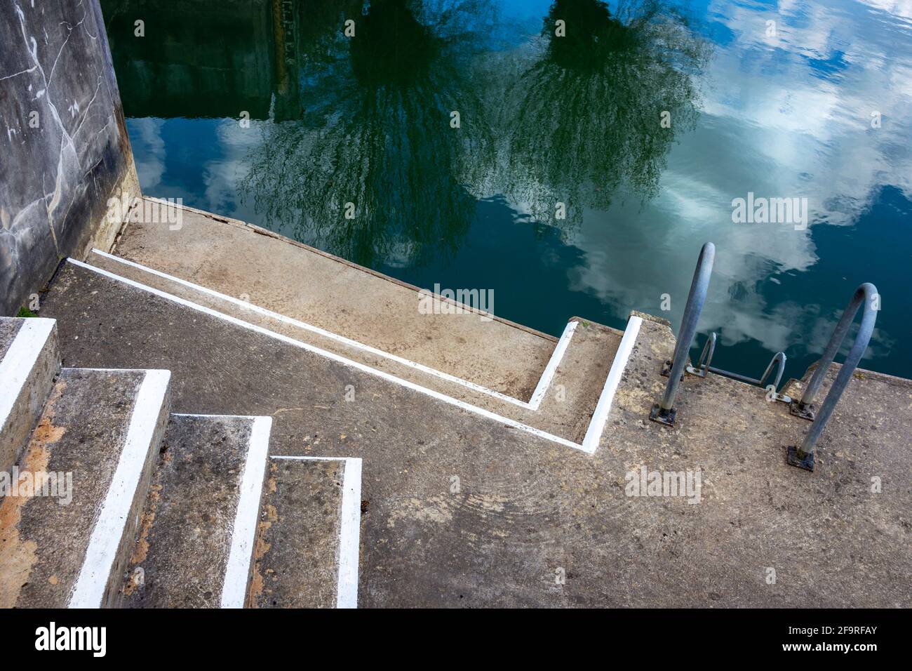 Eingang zum Kanal mit Blick auf den Kanal.die Stufen und Weiße Linien bilden ein abstraktes Textbild Stockfoto