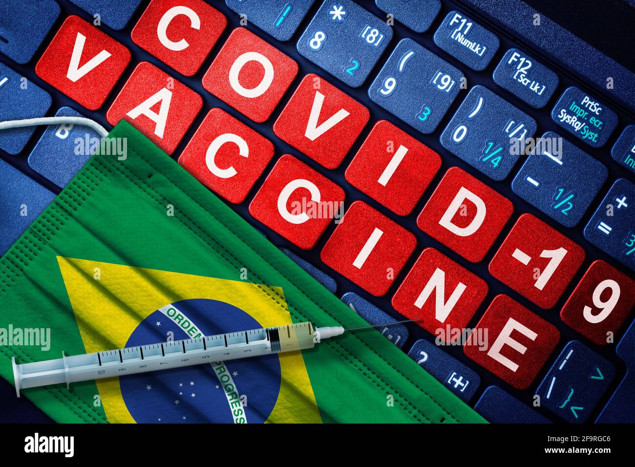 COVID-19-Impfung in Brasilien mit Spritze und Gesichtsmaske mit brasilianischer Flagge und Impfhinweis auf der Computertastatur. Konzept von Covid Vaccinati Stockfoto