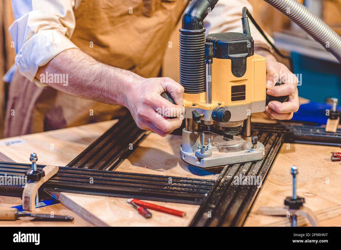 Detail eines Zimmermanns, der einen Router mit einer einstellbaren Schablone verwendet. Stockfoto