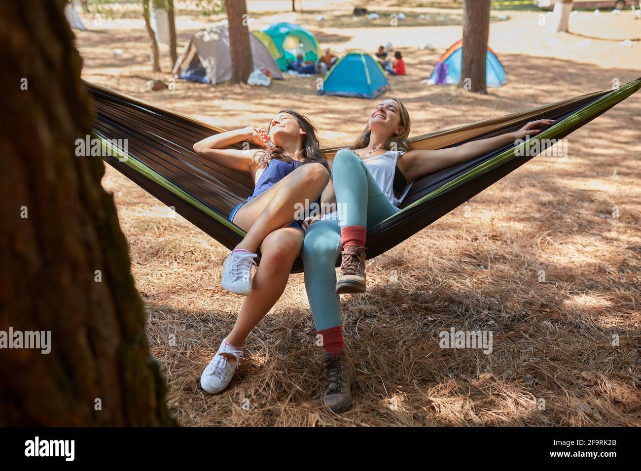 Zwei Freunde haben eine schöne Zeit in ihrer Hängematte als nächstes Zu ihrem Campingplatz Stockfoto