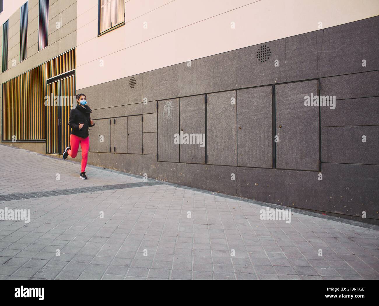 Frau, die auf der Straße läuft, trainiert Stockfoto