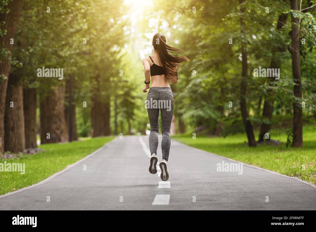 Rückenansicht Von Fit Slim Female Runner Jogging Im Sommer Stadtpark Stockfoto
