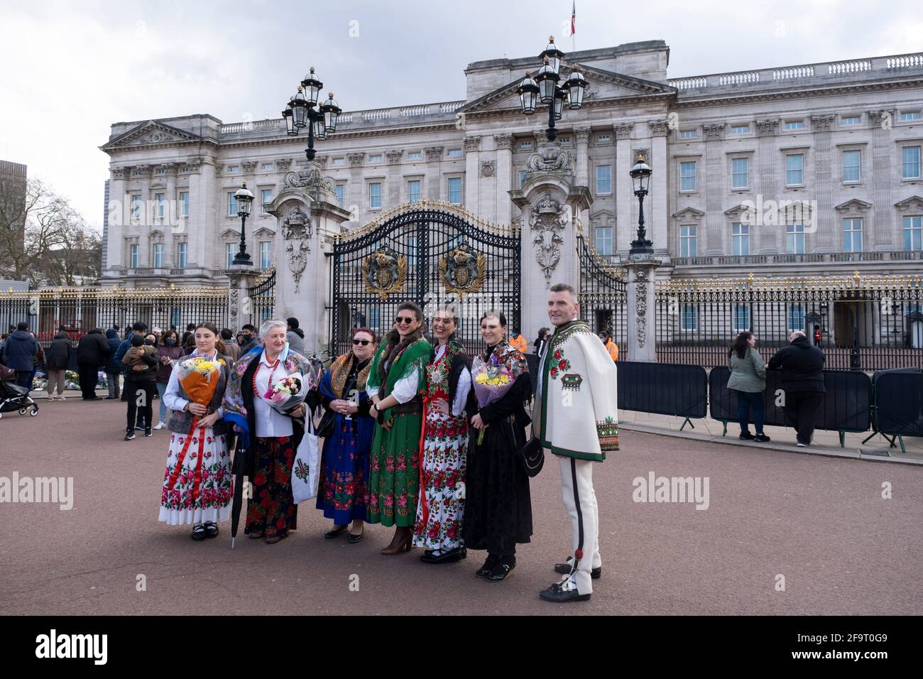 Nach dem Tod von Prinz Philip, Herzog von Edingburgh, vor dem Buckingham Palace am 11. April 2021 in London, Großbritannien, kommt die polnische Familie in traditionellem Highlander-Kleid an, um Blumengebete zu legen. Nach seinem Tod im Alter von 99 Jahren am 9. April 2021 haben Mitglieder der Öffentlichkeit Blumen vor den Toren der königlichen Residenz gelegt. Prinz Philip, Herzog von Edinburgh war ein Mitglied der britischen königlichen Familie als Ehemann von Elizabeth II.. Philip wurde in die griechischen und dänischen Königsfamilien geboren. Stockfoto