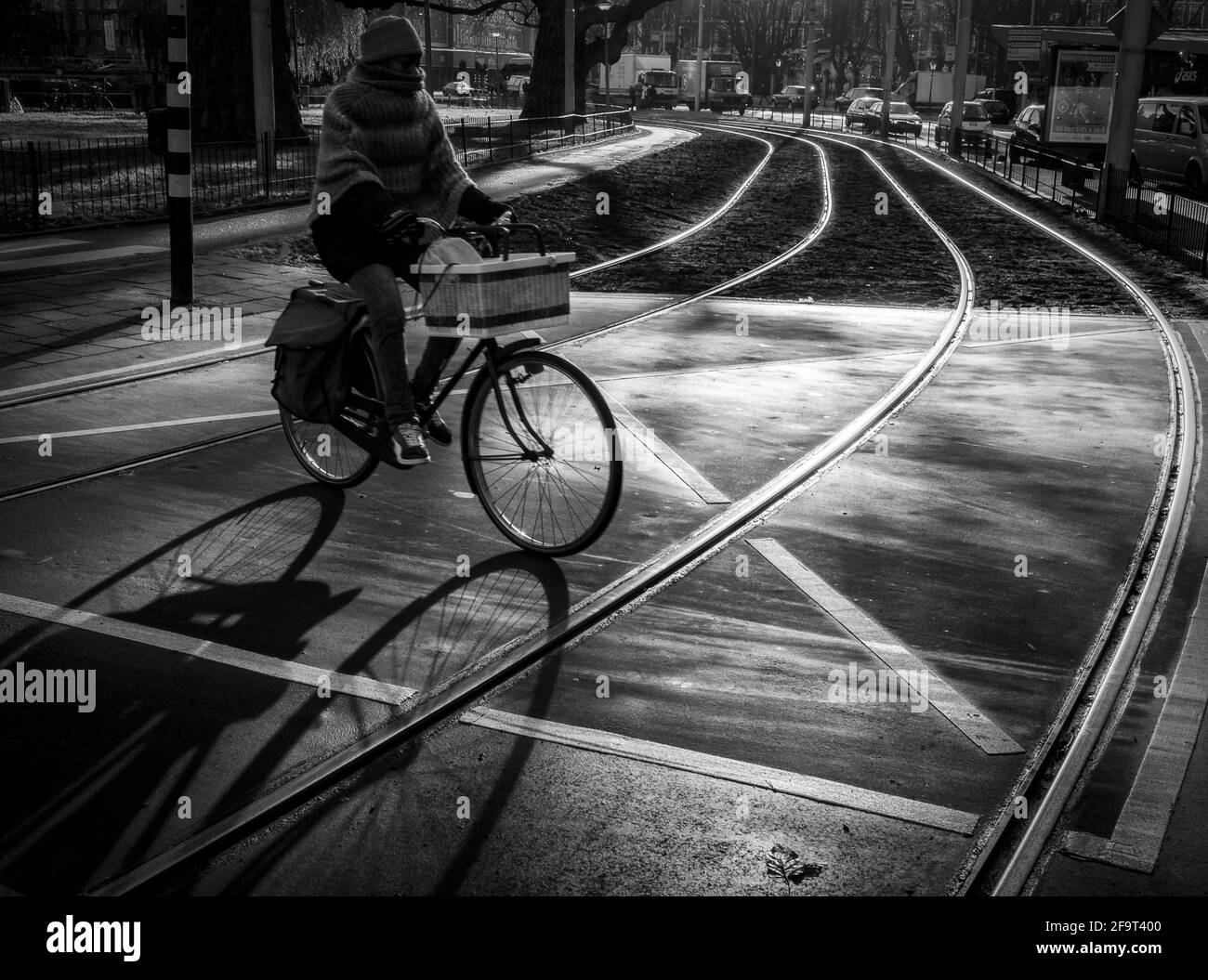 Ein Radfahrer, der durch eine Straße in Amsterdam fährt Stockfoto