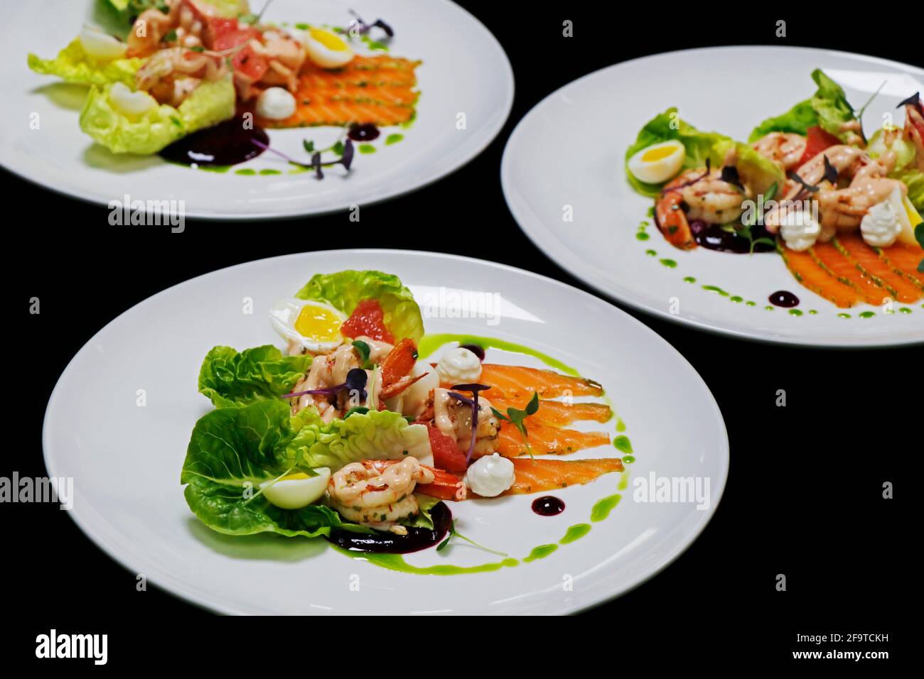 Garnelen-Cocktail und marinierter Lachssalat mit Baby-Edelsteinsalat Und Kräutern Stockfoto