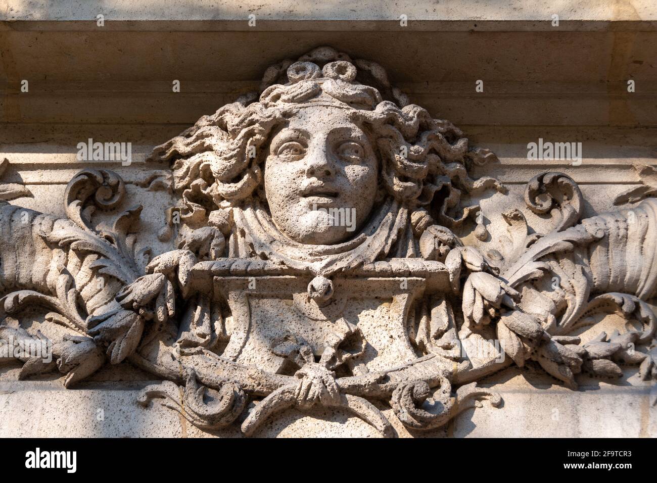 In Stein gemeißeltes Frauengesicht, wahrscheinlich eine Allegorie des Glücks, Fassadenschmuck eines alten Gebäudes in Paris, Frankreich Stockfoto