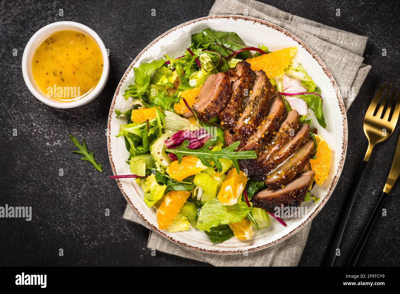 Salat mit gebackener Ente, grünem Salatmix und Orangen. Stockfoto