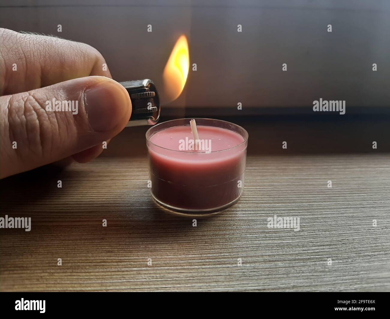 Kerze mit einem Feuerzeug anzünden. Hand hält Feuerzeug mit Flamme  Stockfotografie - Alamy