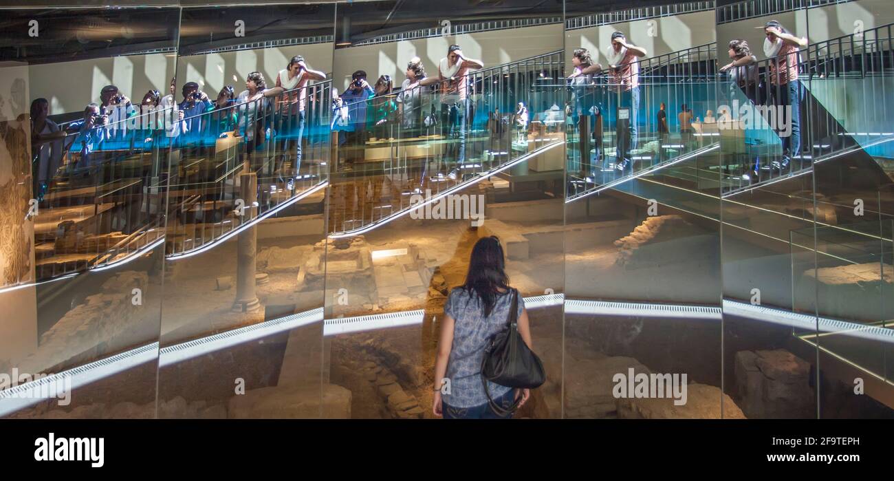 Menschen, die sich im Glas spiegeln, sehen archäologische Überreste in Sevilla, Spanien Stockfoto