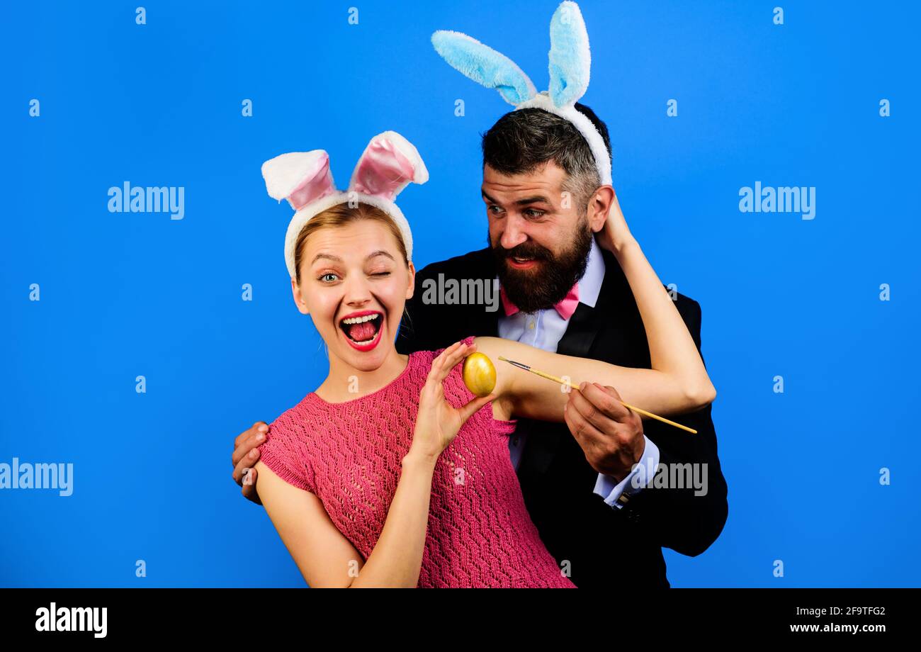 Familie feiern Ostern und malen Ei. Paar in Hasenohren Viel Spaß. Stockfoto