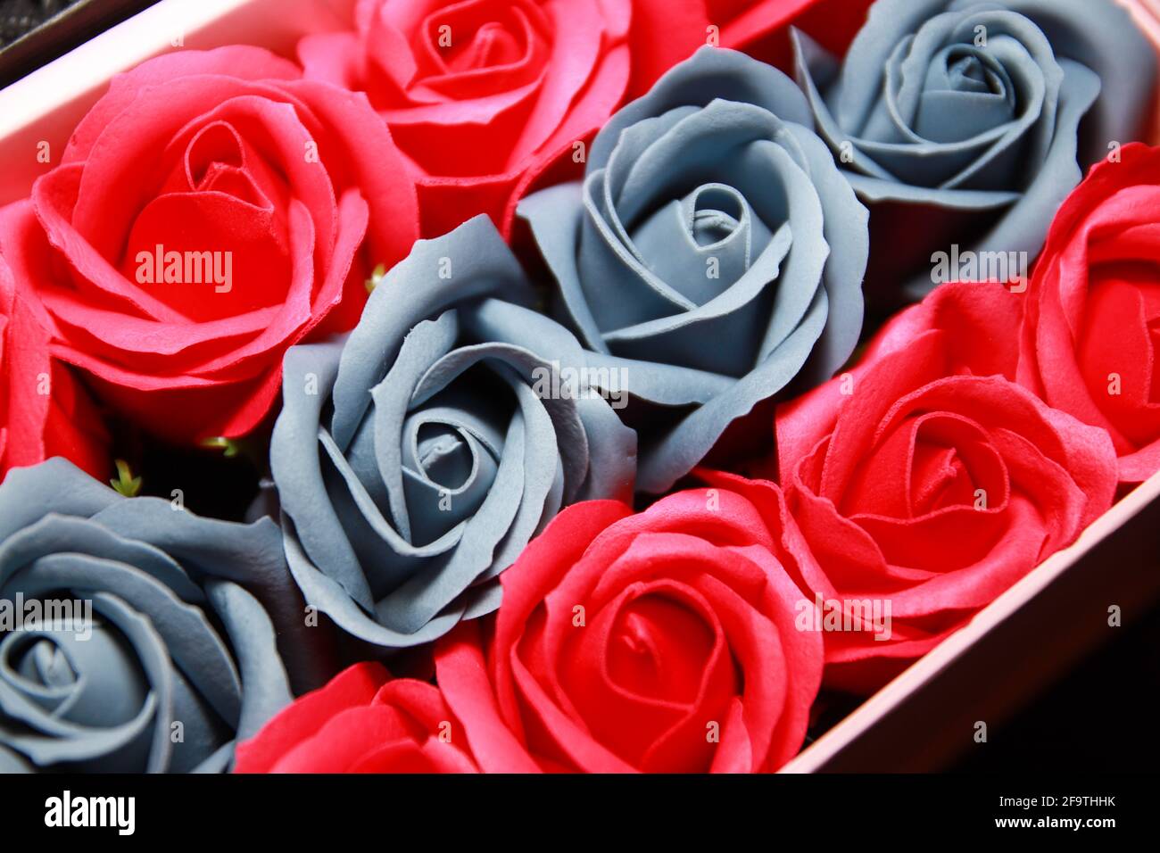 Rote und graue Rosen Hintergrund. Künstliche Blumen. Stockfoto