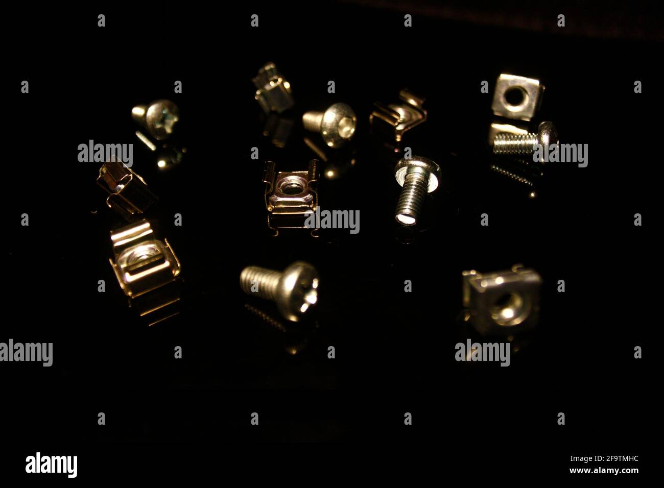 Rack-Daten-Schraube und Schrauben auf schwarz isoliert mit Reflexionen Stockfoto
