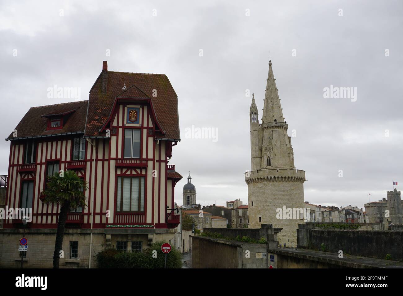 Rotes, altes Fachwerkhaus und Steinkirche in der Innenstadt von La Rochelle, Frankreich Stockfoto