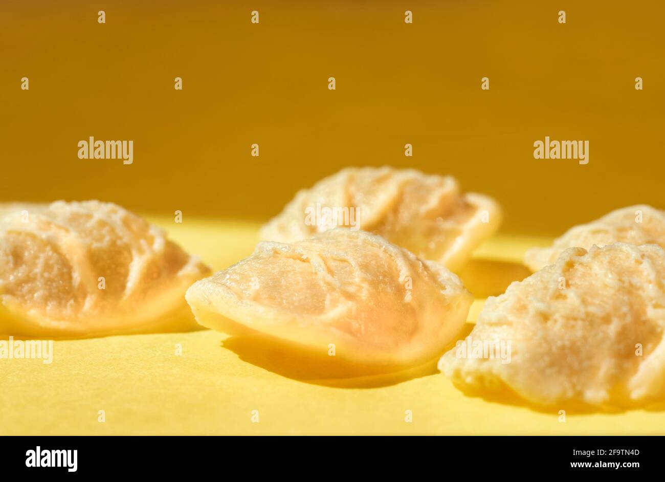 Orecchiette Pasta auf farbigem Hintergrund, eine kleine ohrförmige Pasta Mit der Mitte dünner als die Kante und eine raue Oberfläche Stockfoto