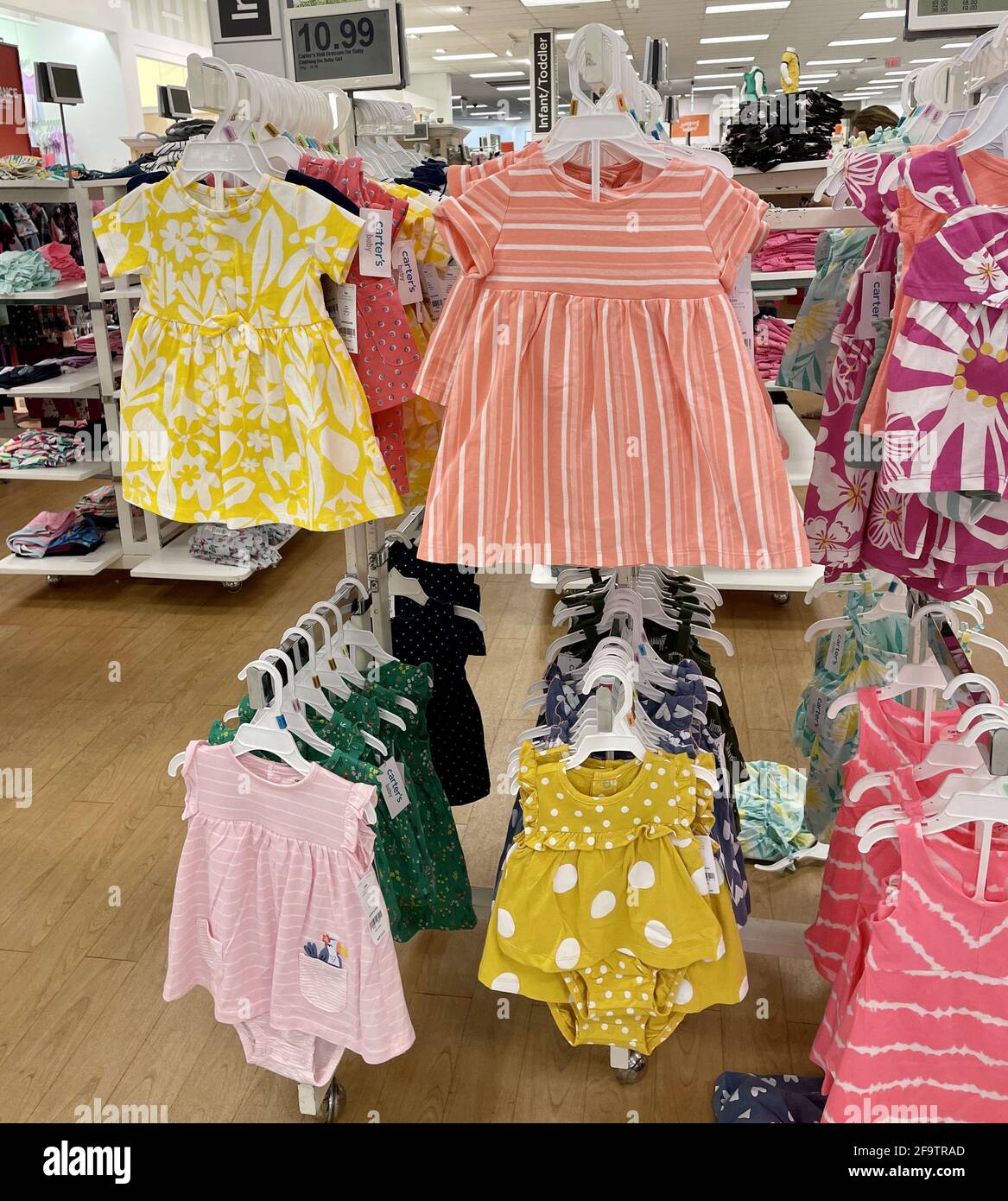 FRESNO, USA - 17. Apr 2021: Ein Foto der neuen Sommer-Outfits 2021 für kleine Mädchen/Kleinkinder in leuchtend orangen und gelben Farben im Store han Stockfoto