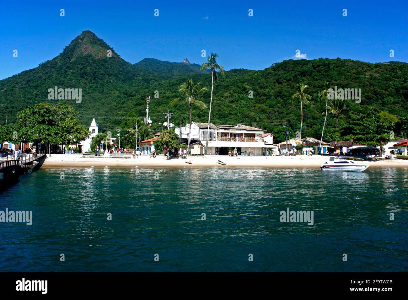 VILA DO ABRAÃO, ILHA GRANDE, RIO DE JANEIRO, BRASILIEN - 10. APRIL 2011: Panoramablick auf das Dorf von einem Boot aus. Dahinter die Berge und der Dschungel. Stockfoto