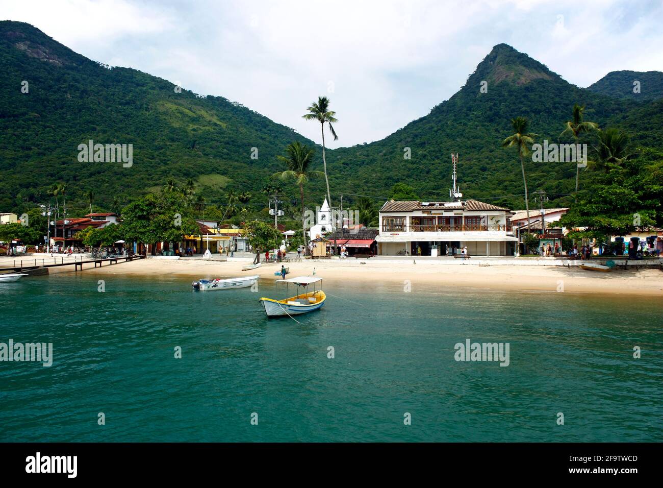 VILA DO ABRAÃO, ILHA GRANDE, RIO DE JANEIRO, BRASILIEN - 10. APRIL 2011: Panoramablick auf das Dorf von einem Boot aus. Dahinter die Berge und der Dschungel. Stockfoto