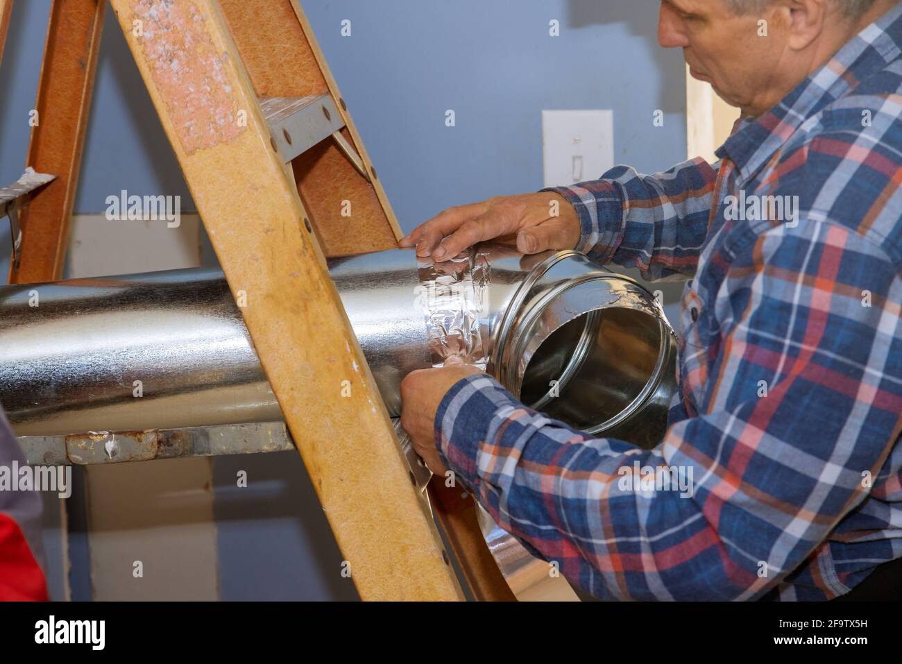 Montage der Klimaanlage unter der Innendecke vor der Fertigstellung des Innenraums. Stockfoto