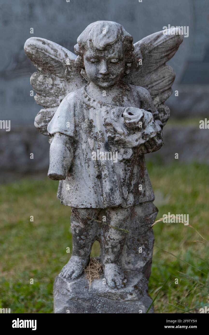 Stone Angel wacht über einen ruhigen Friedhof in Quebec, Kanada. Jahre des Seins in den Elementen sind in der Abnutzung auf der Satzung und die fehlende gezeigt Stockfoto
