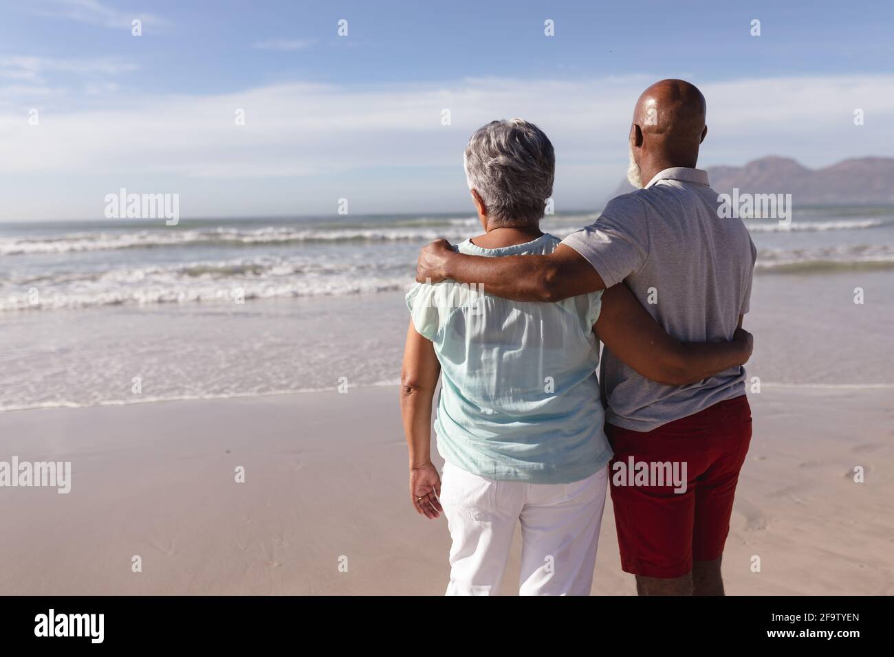 Rückansicht eines älteren afroamerikanischen Paares, das sich umarmt Am Strand Stockfoto