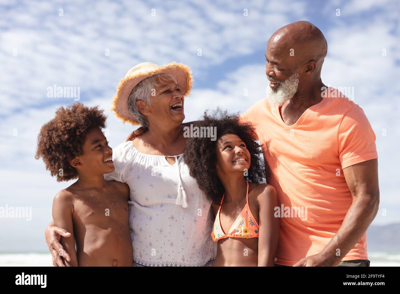 afroamerikanische Großeltern und Enkelkinder lächeln am Strand Stockfoto