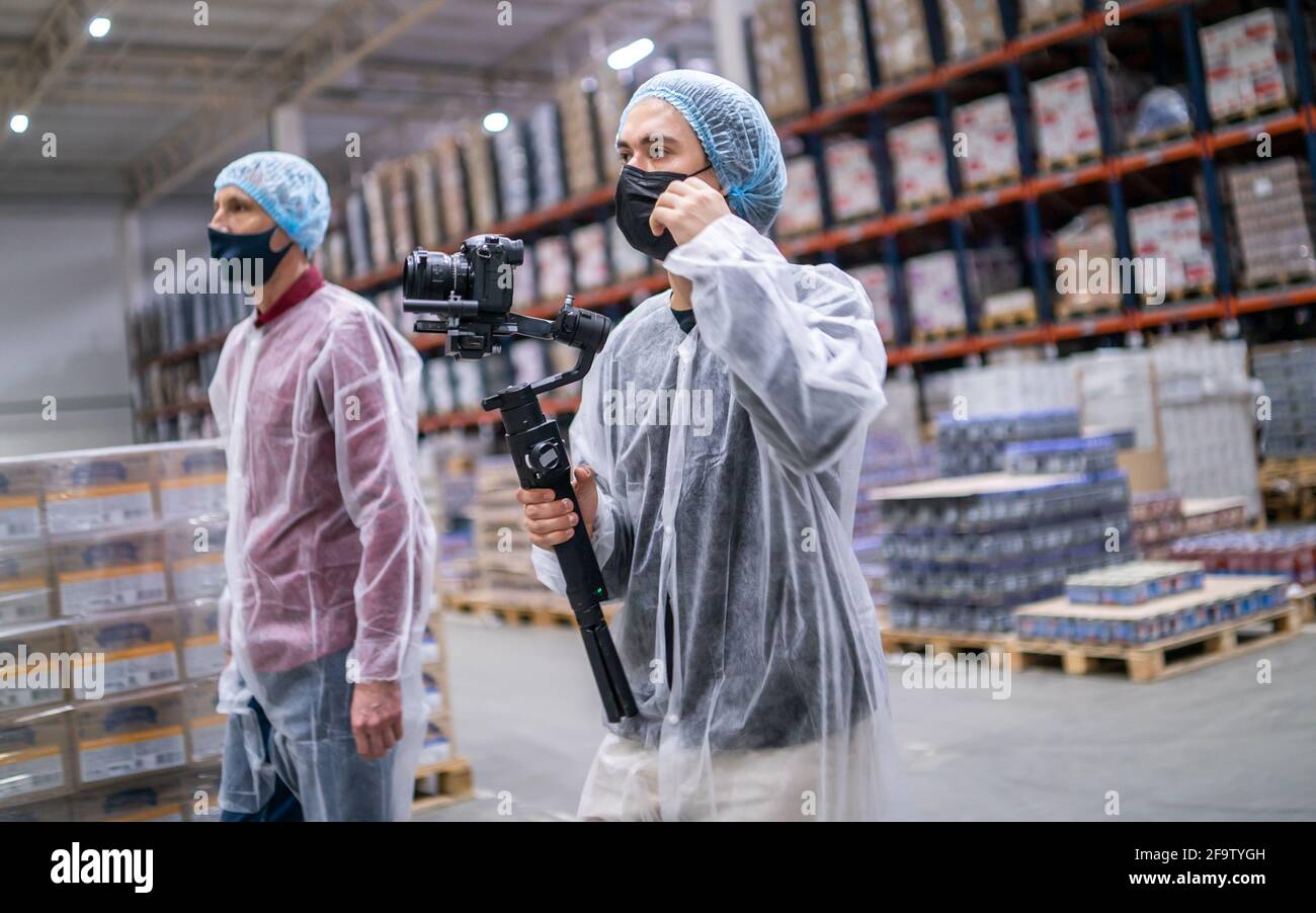 Junge Operatoren in medizinischen Schutzanzug mit Kamera Stockfoto