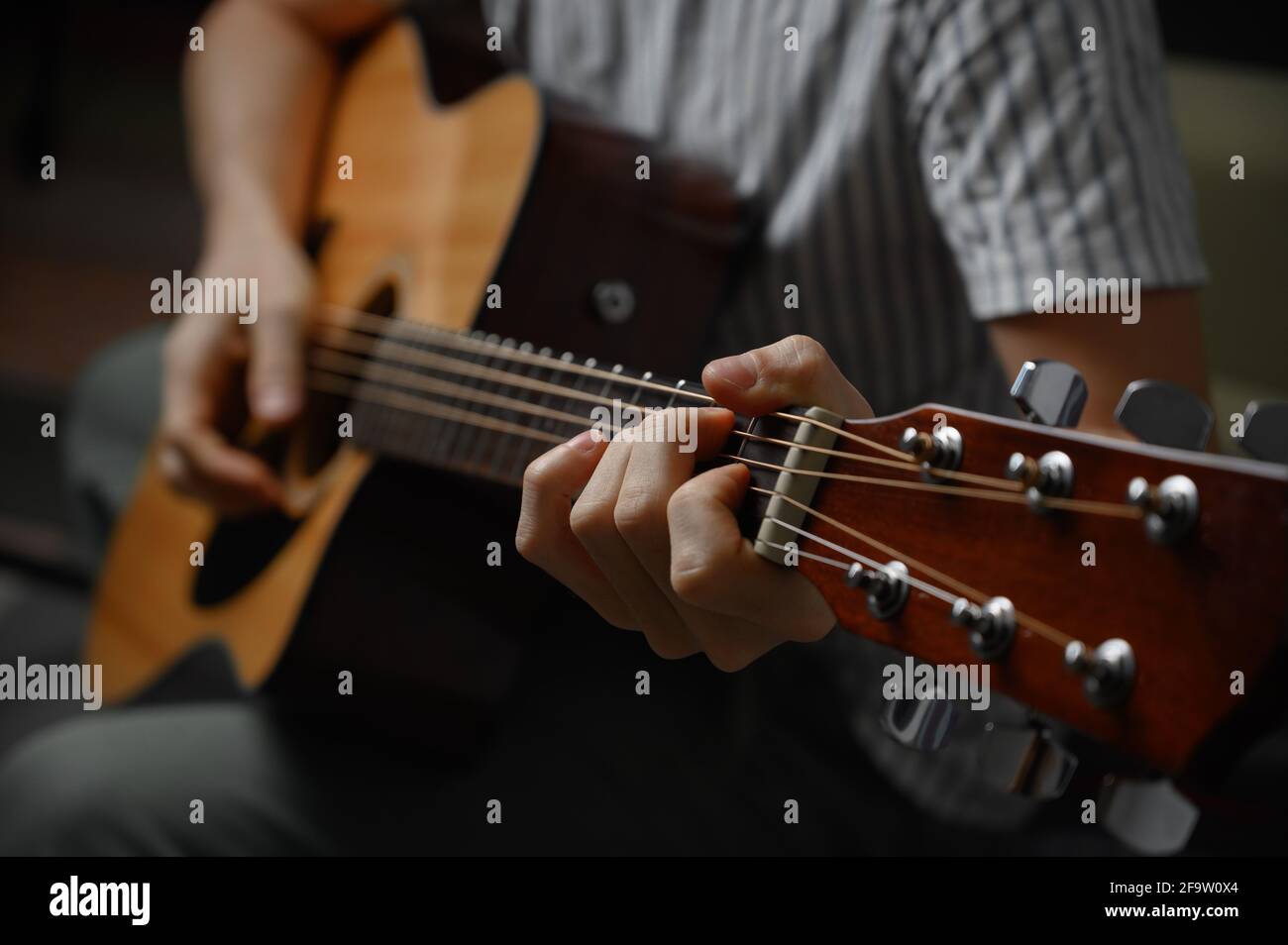 Mann spielt akustische Gitarre, Cover für Online-Kurse, Lernen zu Hause. Stockfoto