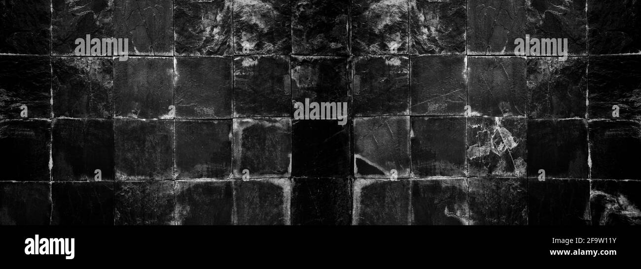 Schwarze alte Kachel Stein Wand Hintergrund mit dunkler Farbe für Design in Ihrem Arbeitshintergrund. Stockfoto