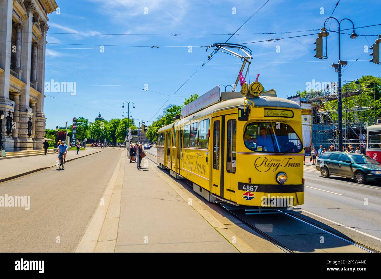 WIEN, ÖSTERREICH, 08. JUNI 2015: Berühmte Wiener Ringstraße mit historischem Burgtheater und traditioneller roter Straßenbahn Stockfoto