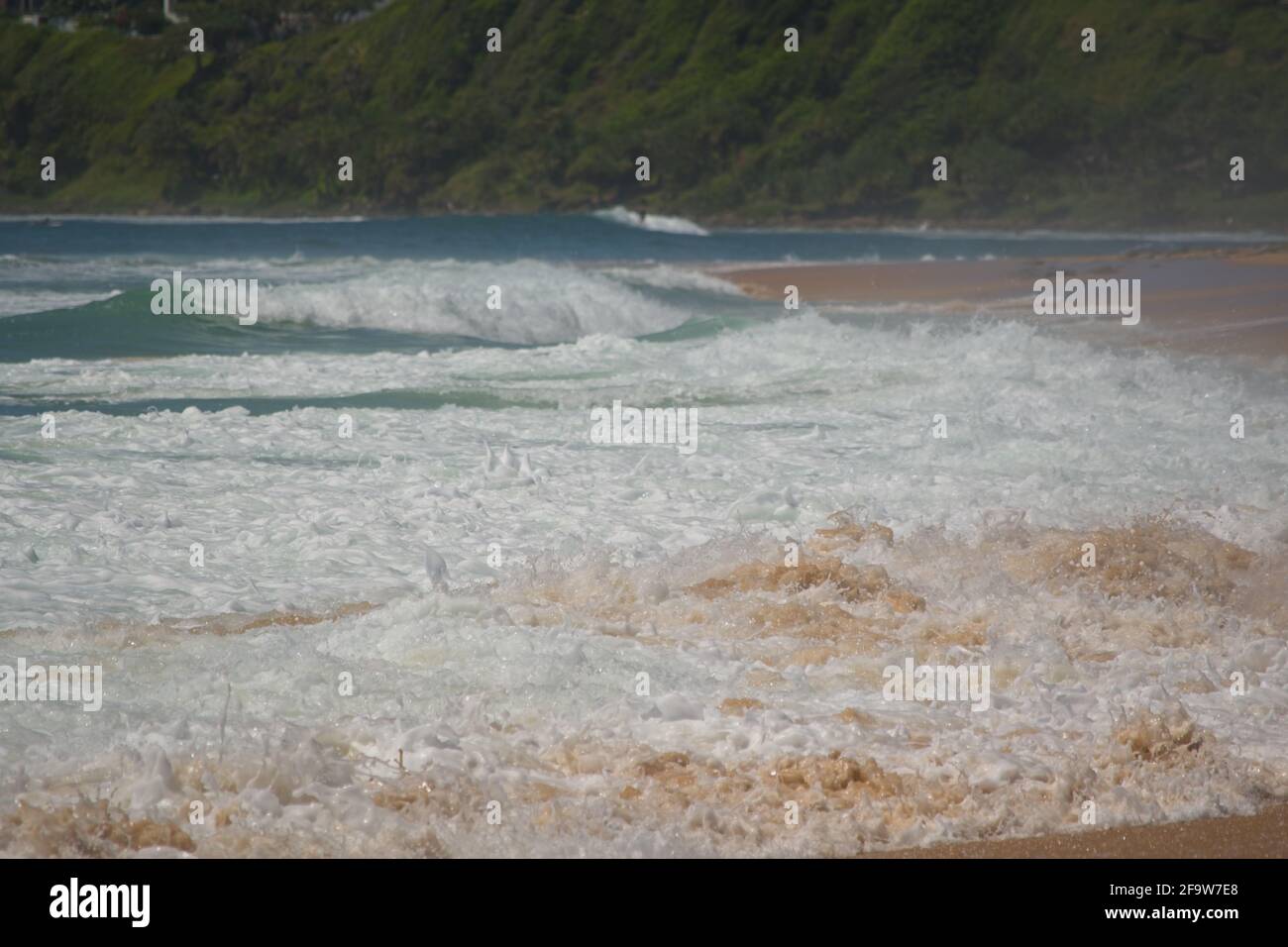 Wellen Rollen am Sandstrand - aus nächster Nähe Stockfoto
